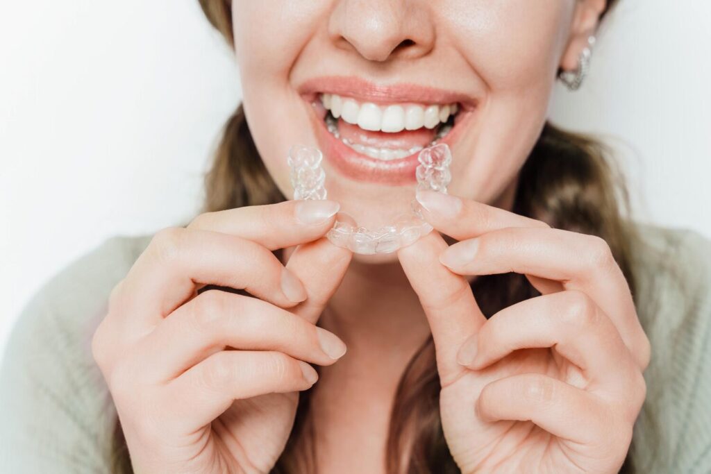 Smiling Woman Holding Clear Teeth Aligner 410521 1497 Smiling Woman Holding Clear Teeth Aligner 410521 1497