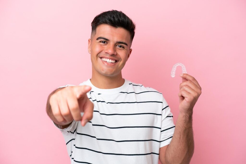 Young Caucasian Man Holding Invisaling Isolated Pink Background Points Finger You With Confident Expression 1368 342562 Young Caucasian Man Holding Invisaling Isolated Pink Background Points Finger You With Confident Expression 1368 342562